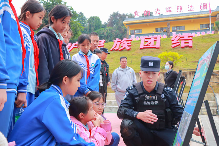 图为孟定边境派出所所民警通过发放法律漫画讲解图册、现场教学、放置警示案例展板等方式，向学校学生、老师讲解法律知识（陈云峰摄）-(2)(1).jpg